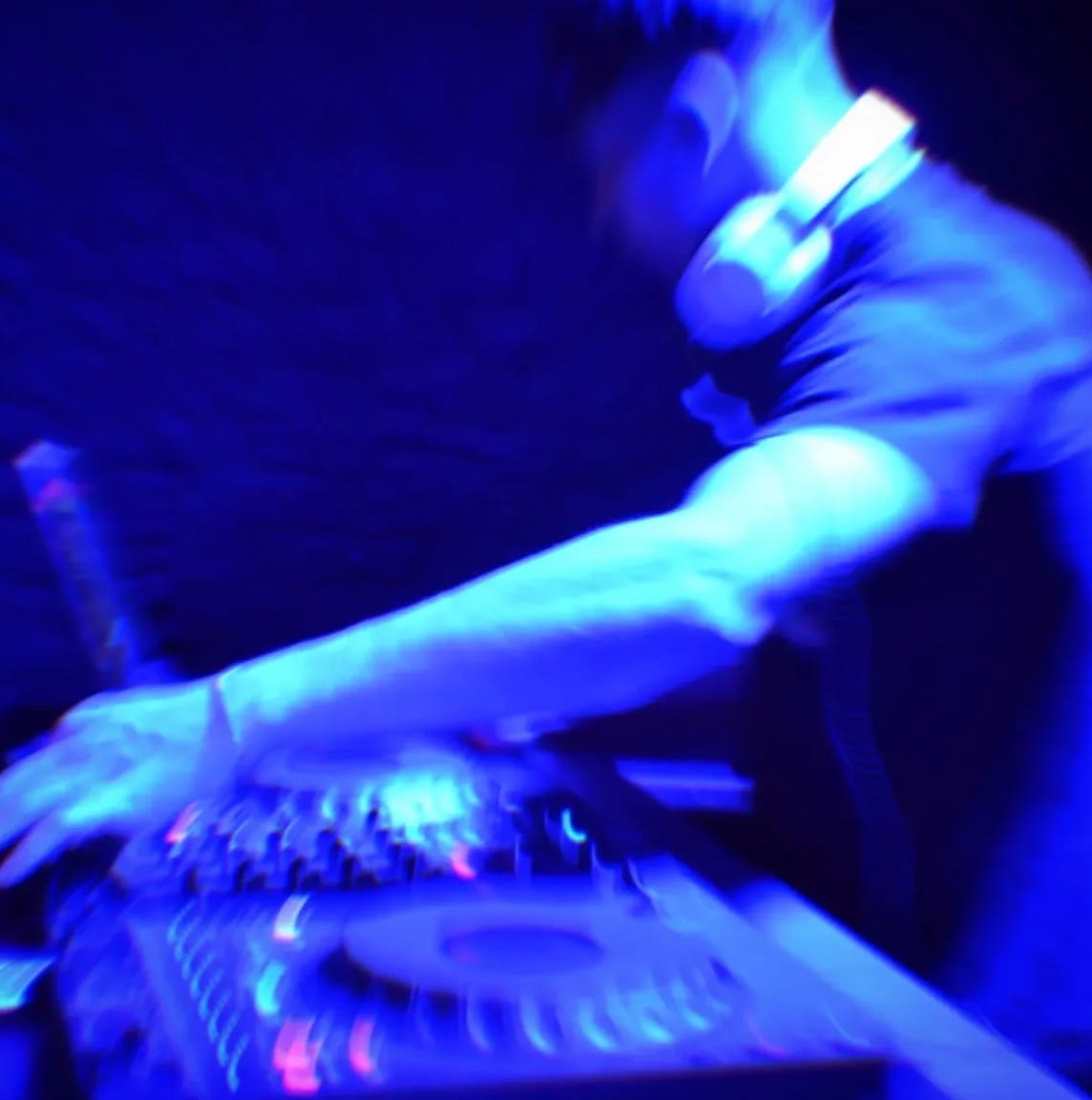 DJ Crni za pultom u klubu, plavo svjetlo
